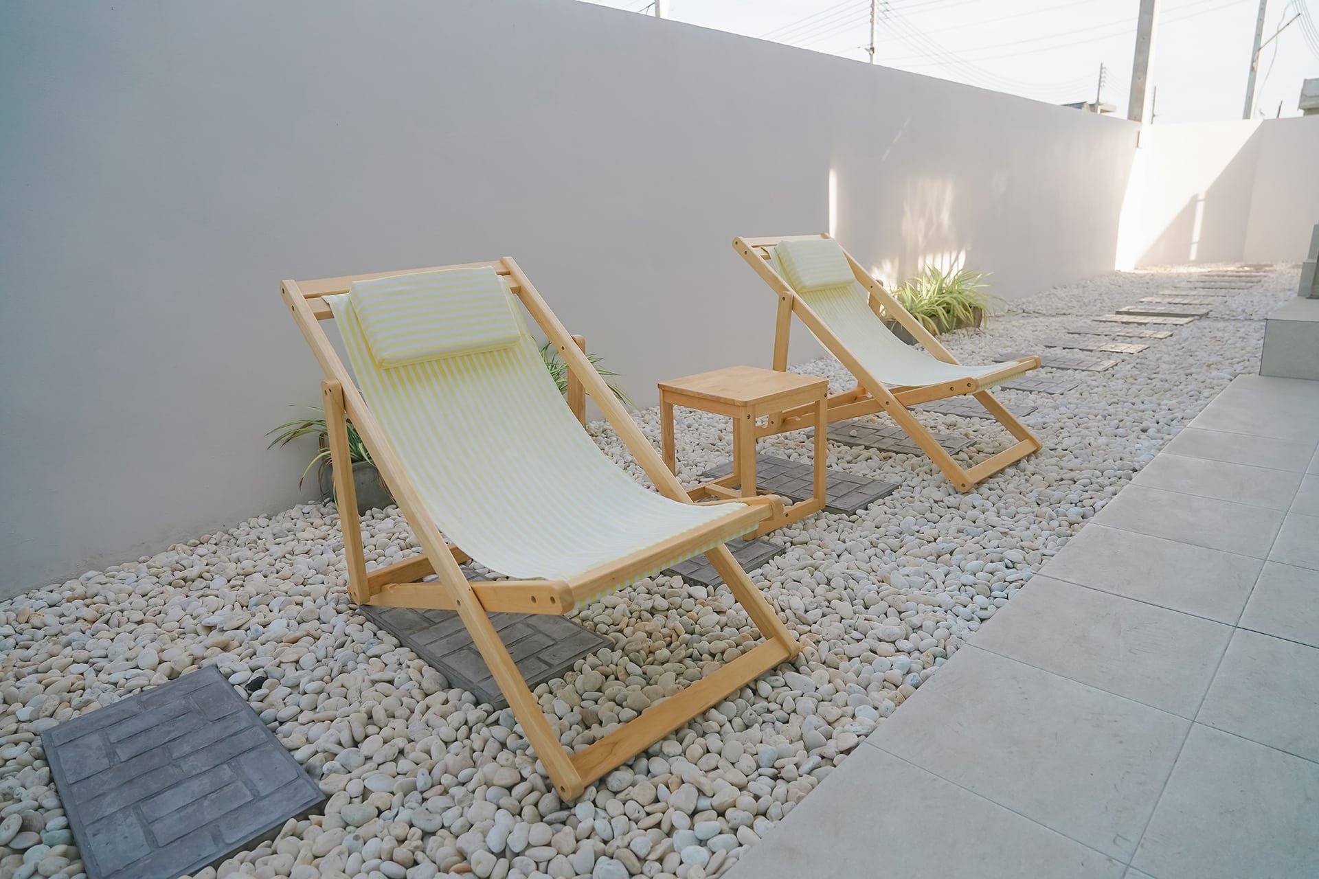 Yellow,White,Striped,Wooden,Deck,Chair,On,Pebble,Sea,Shore