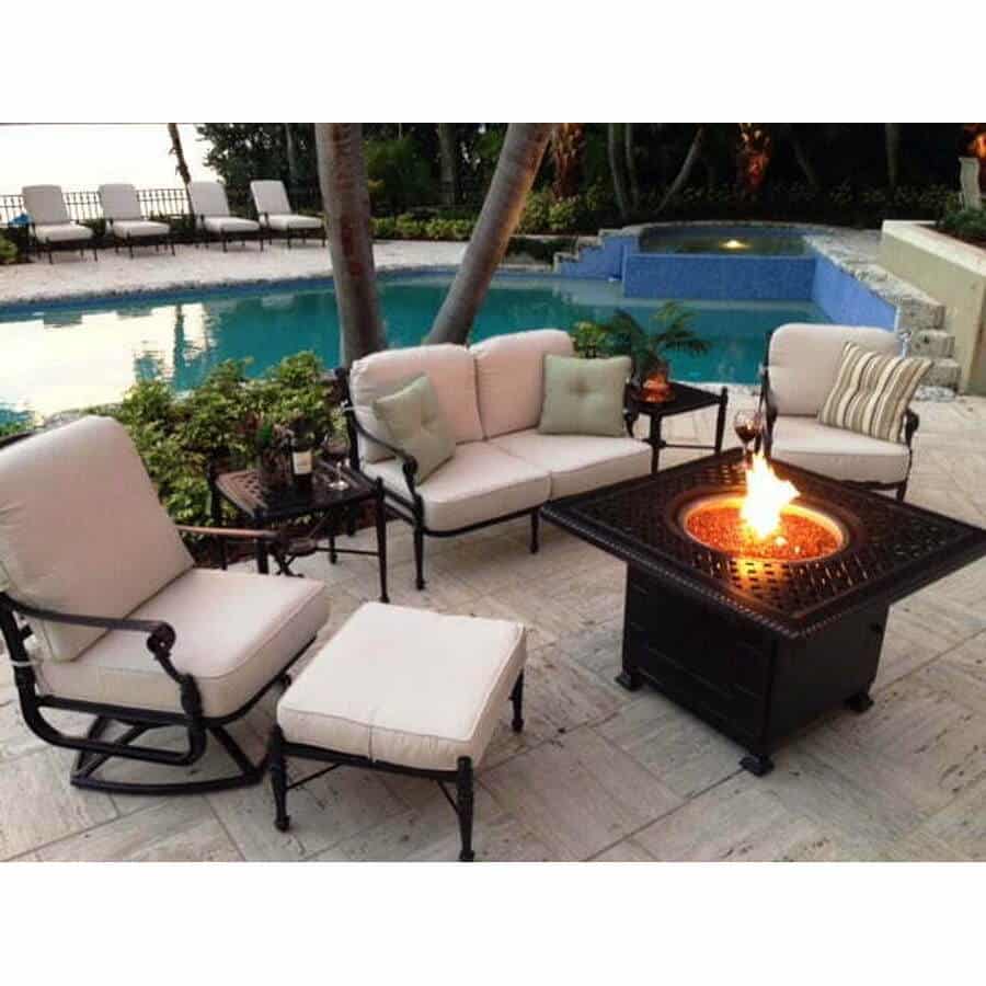 Dark patio furniture frames with light cushions around a fire table