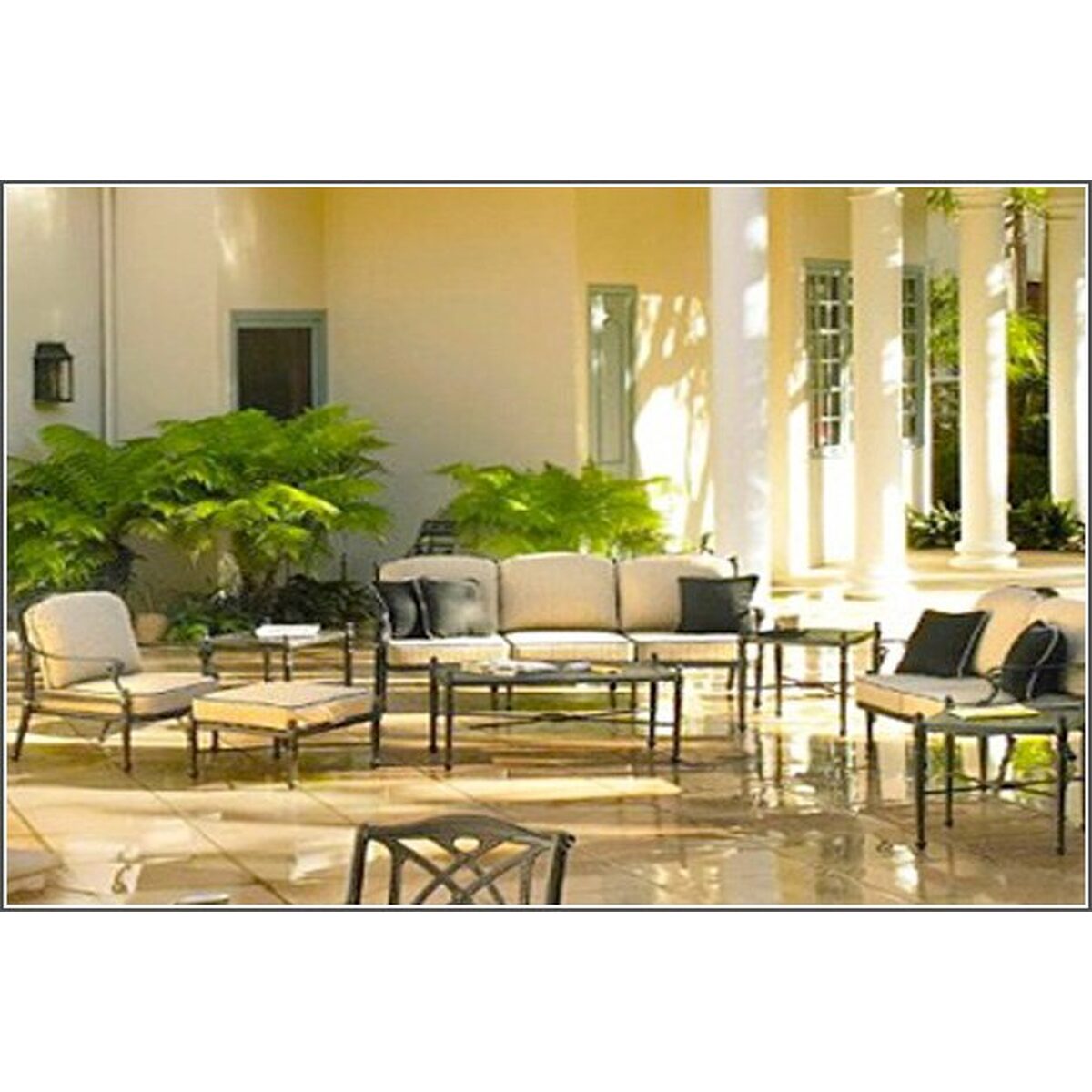 Dark patio seating with light cushions in a bright sunroom