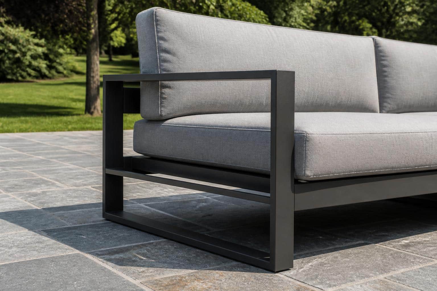 Close view of an aluminum outdoor sofa showing the front rail, seat cushion thickness, and back pillow placement on a Charlotte patio