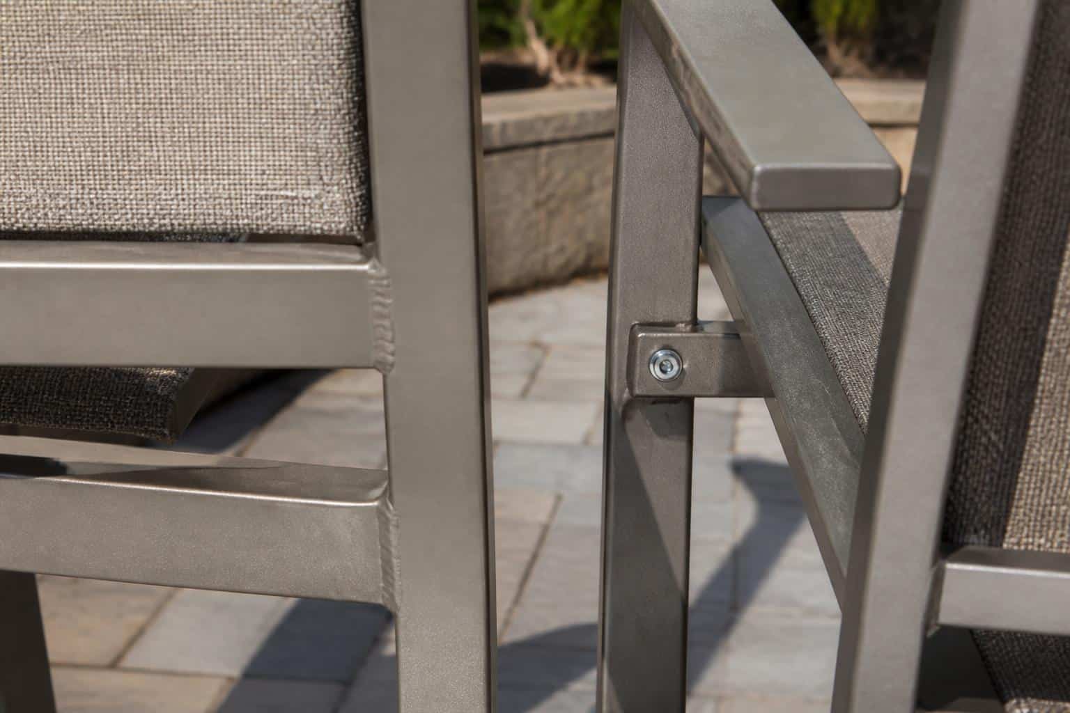 Close view of an aluminum patio chair frame showing a smooth welded corner and finish coverage