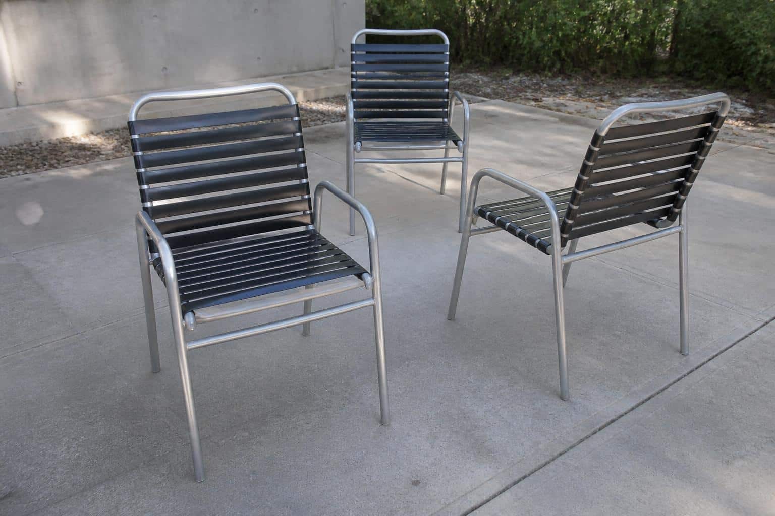 Aluminum dining chairs arranged around a patio table showing consistent frame lines and joinery