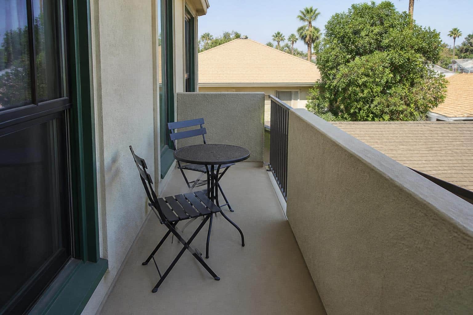 Two-chair bistro arrangement with clear pull-out space on a compact urban balcony