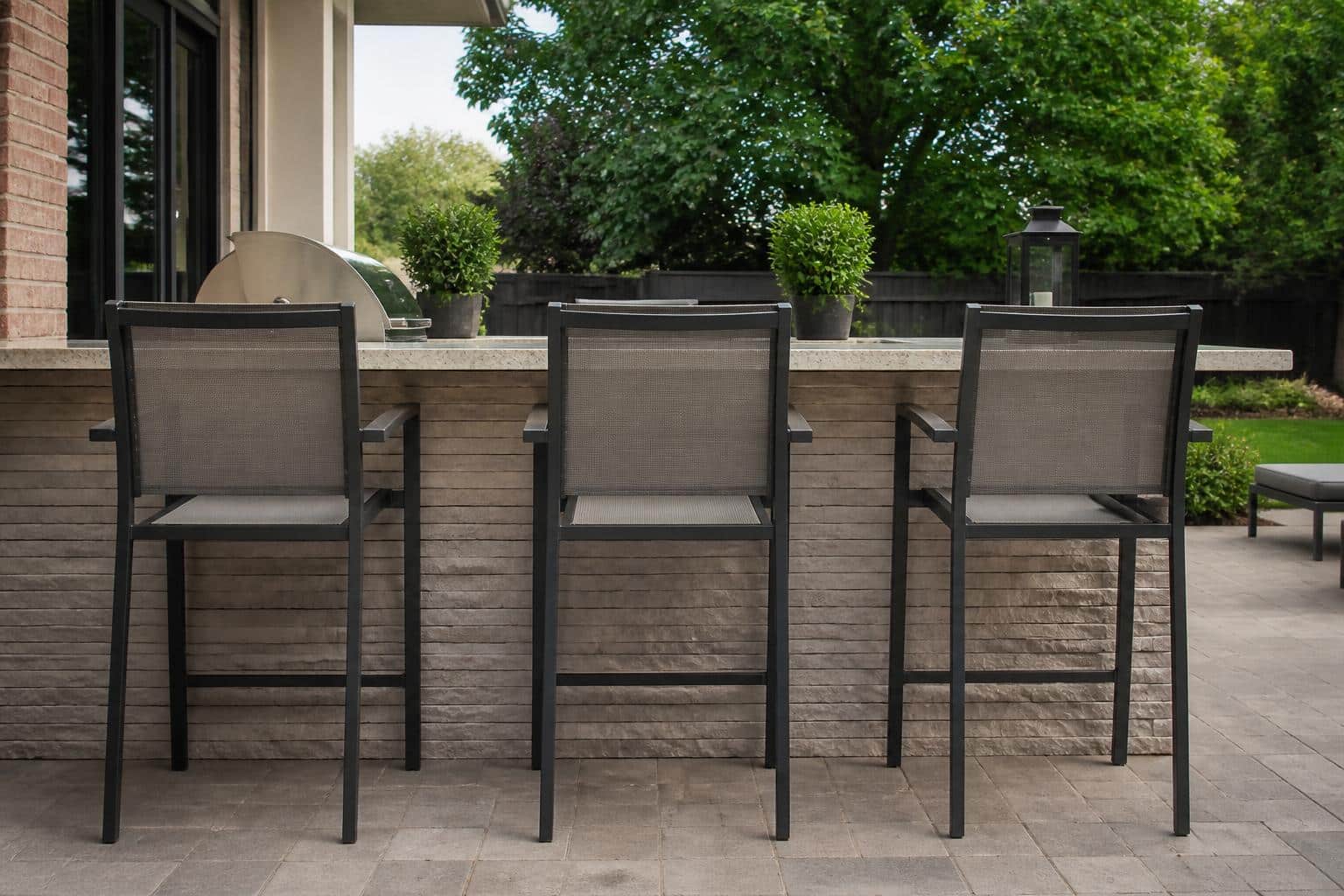 Outdoor bar stools lined up at a patio counter