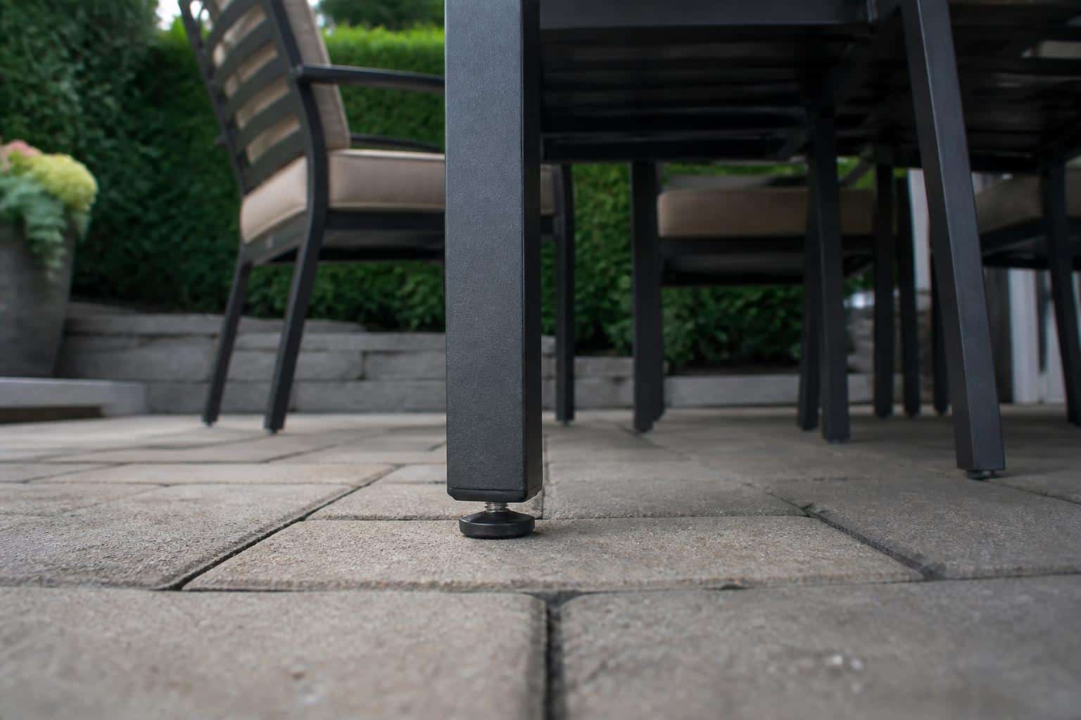 A full outdoor dining arrangement sitting level across a mixed paver and concrete Charlotte patio