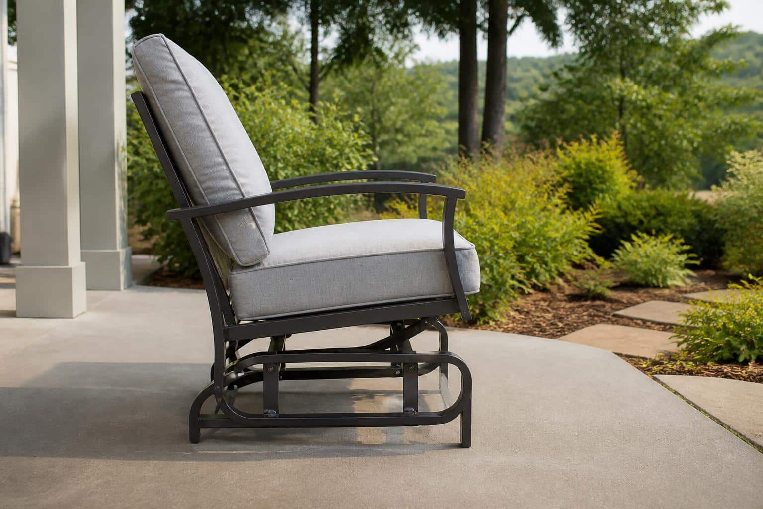 Close view of an outdoor glider chair on a covered Charlotte porch showing the space needed behind the frame for full front-to-back travel