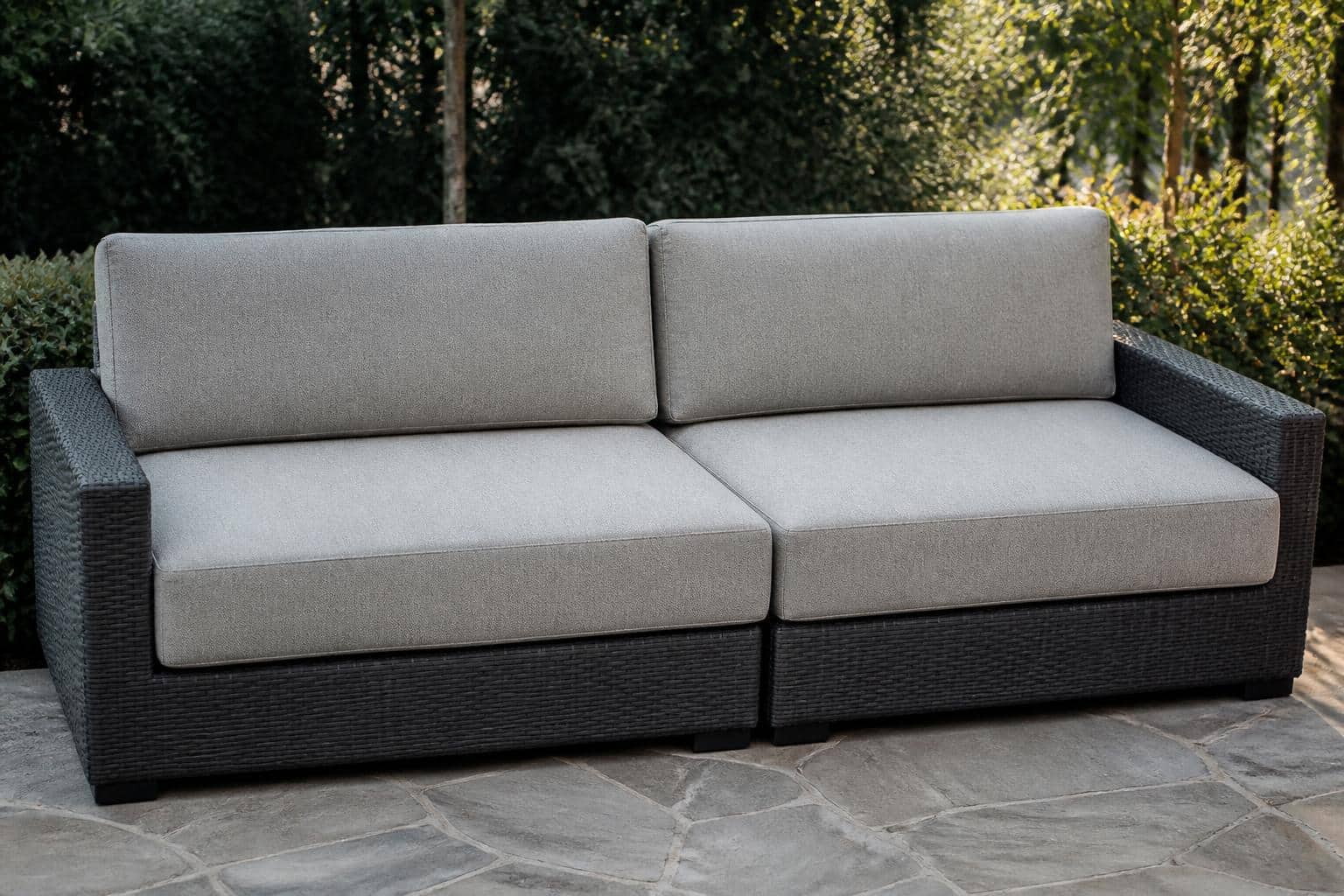 Wider view of a modular outdoor sectional arrangement with cushions aligned across the seams on a residential patio