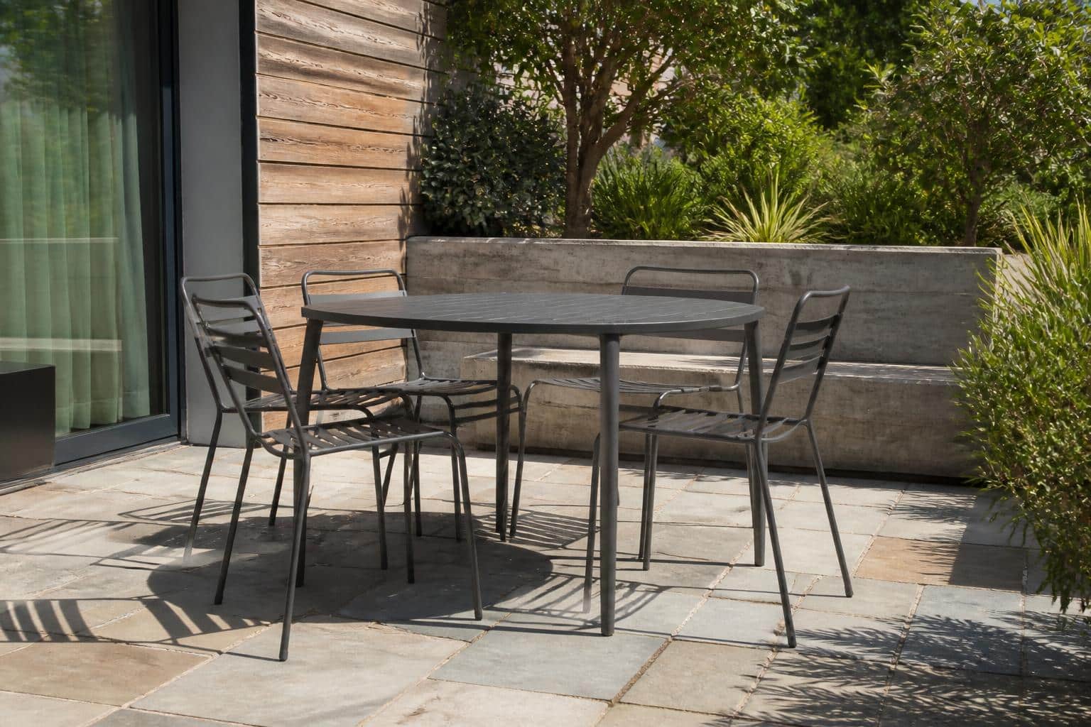 Wide view of a covered Charlotte patio with a rectangular outdoor dining table and six chairs arranged with generous walkway clearance