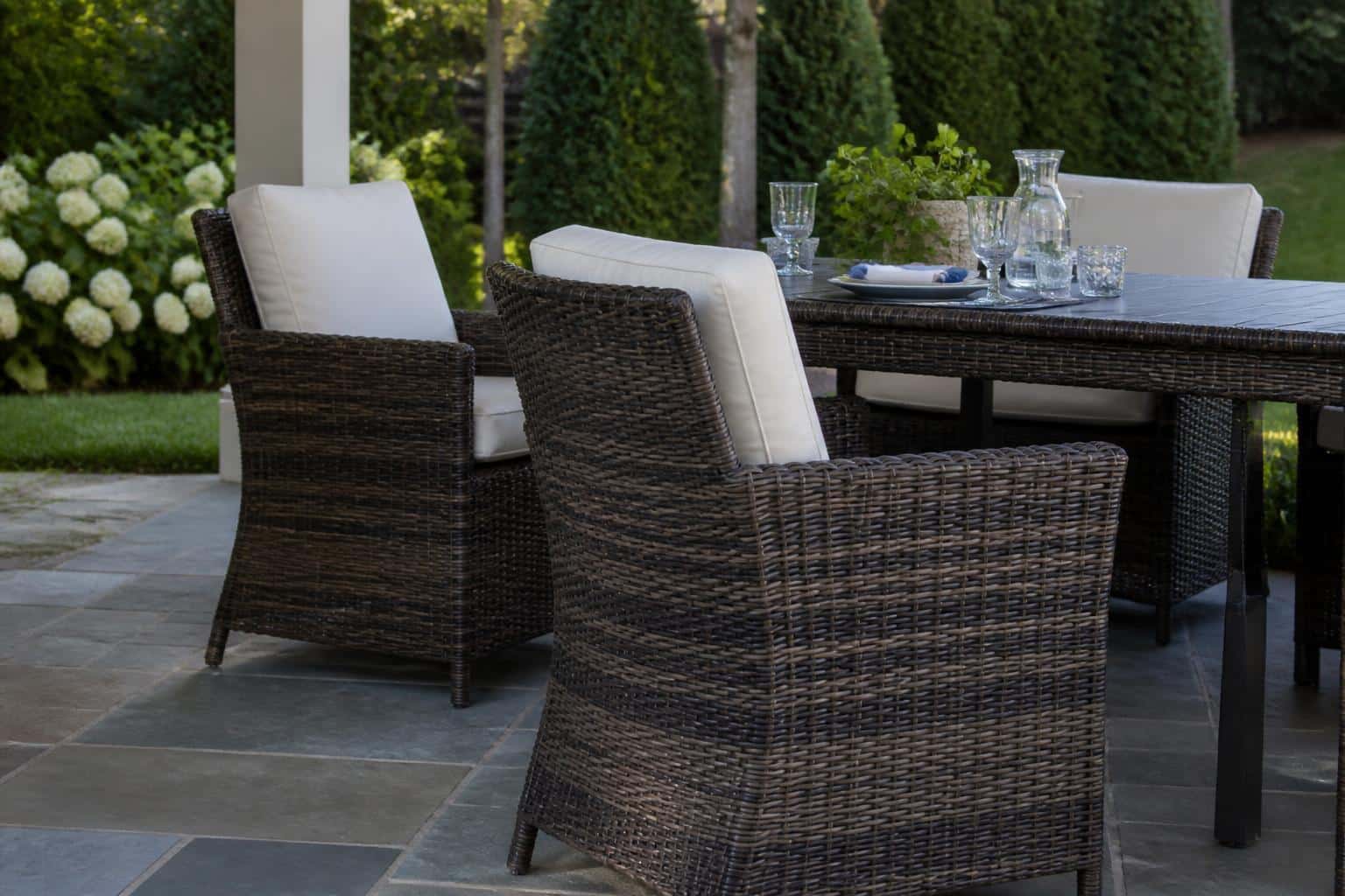 Resin wicker dining chairs beside an outdoor table