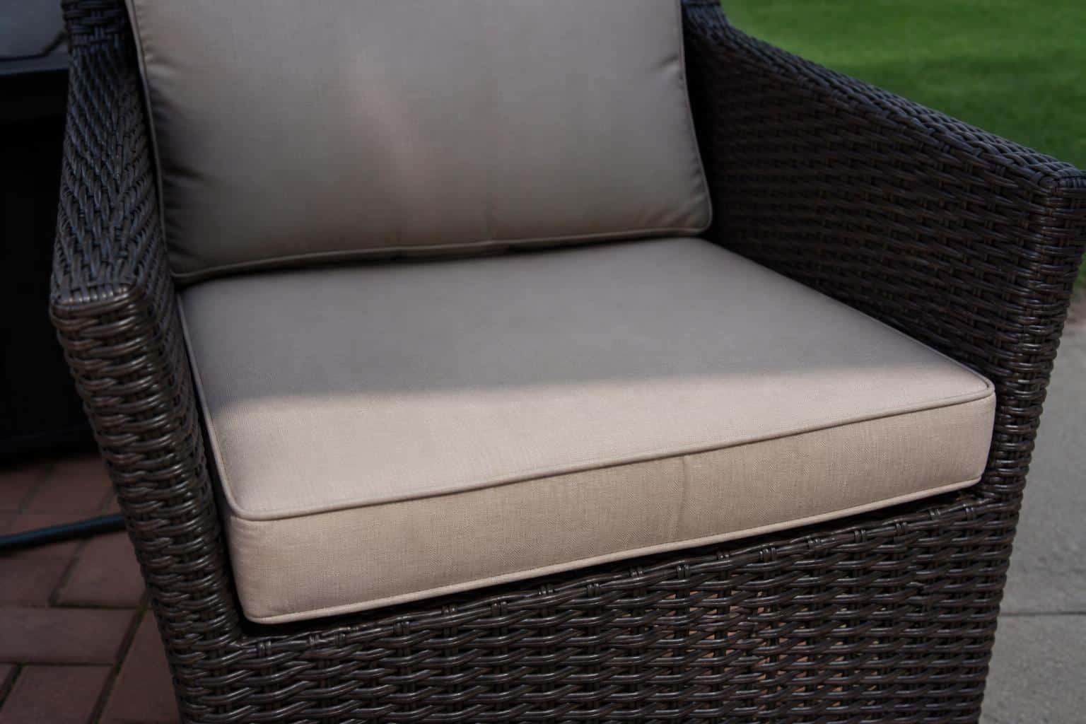 Close view of a curved wicker seat with a shaped cushion showing front width, back taper, and side ties