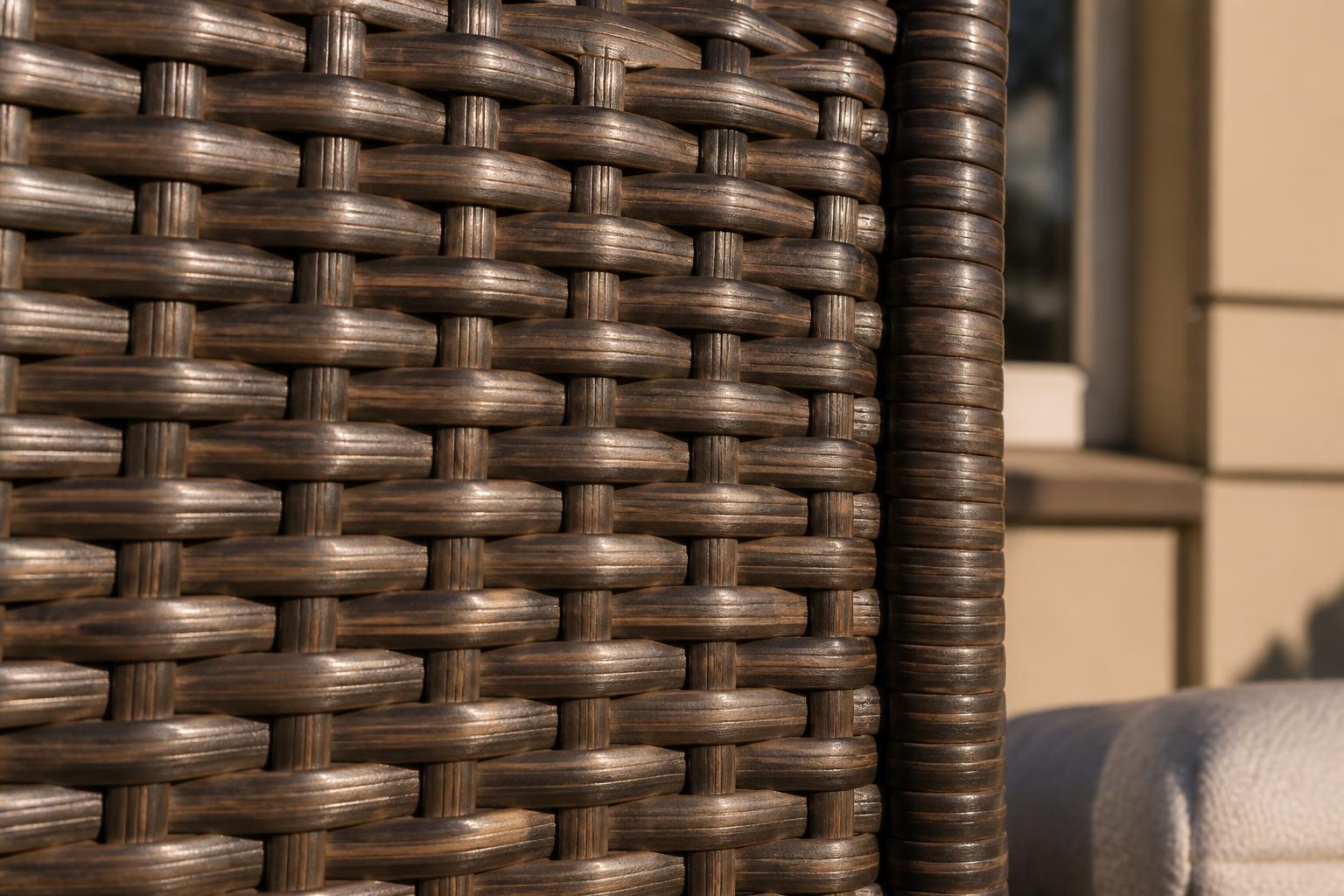 Close-up of dark brown woven resin wicker strands on an outdoor chair back