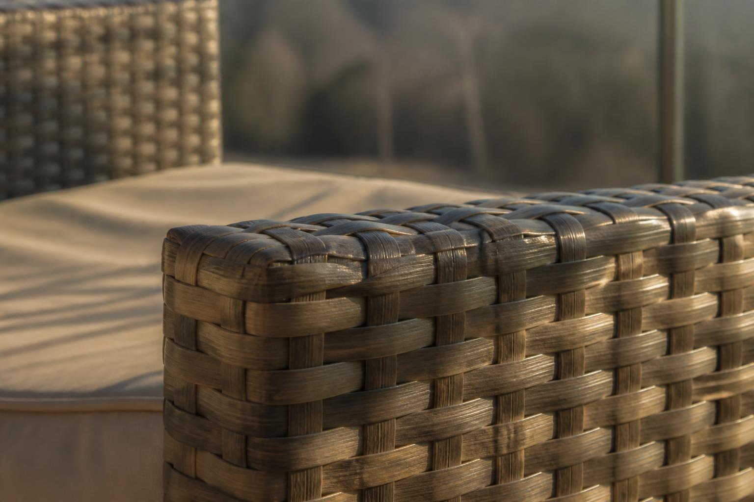 Close-up of the top edge of a woven resin wicker outdoor chair arm
